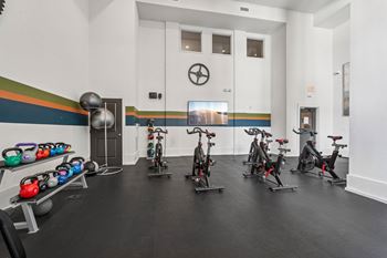 A gym with exercise bikes and kettlebells.